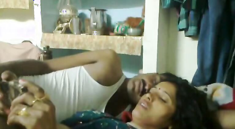 Mumbai raand after sex with her pimp laying watching a porn movie on his mobile who is playing with her boobs.